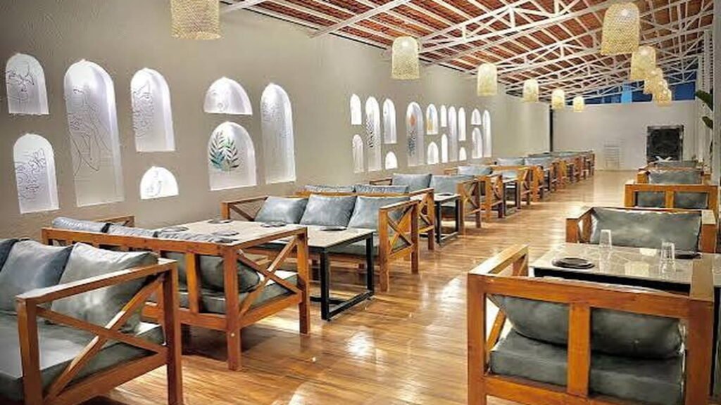 Spacious wooden seating and bright interiors at The Palms, one of the Live Music Restaurants in Sambhajinagar.