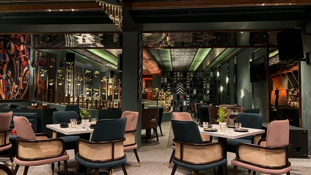 Uptown501 outdoor dining with tropical plants and café seating among Live Music Restaurants in Sambhajinagar.
